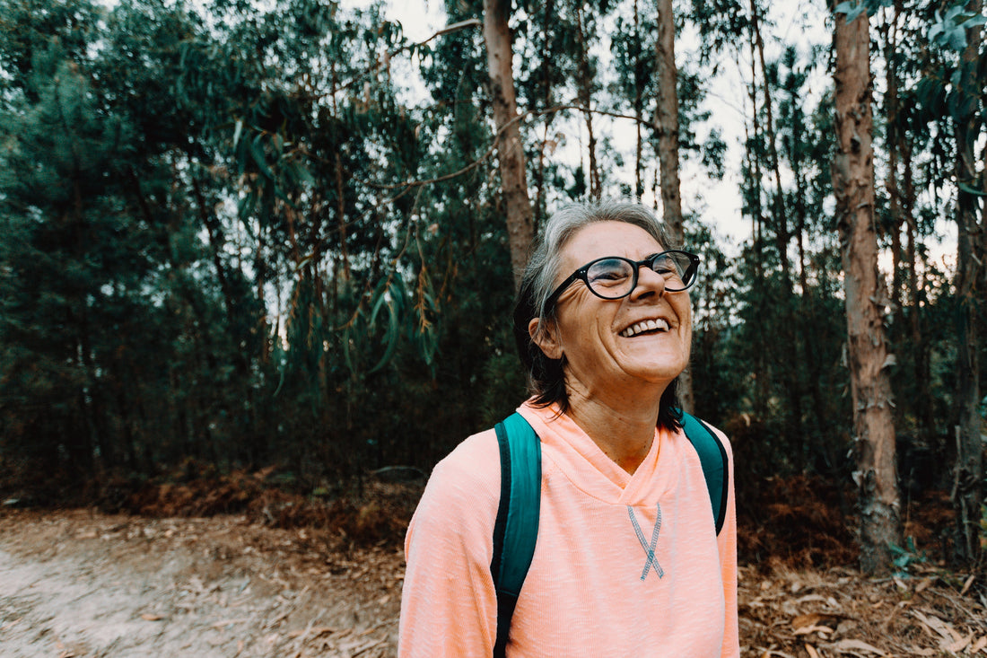 ADHD Friendly To-Do List: How to Stay Focused and Get Things Done with a photo of a smiling older woman wearing glasses in a grove of trees.